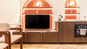 Moderni keittiö, jossa on suuri litteänäyttöinen televisio, puiset kaapit ja sisäänrakennettu uuni.