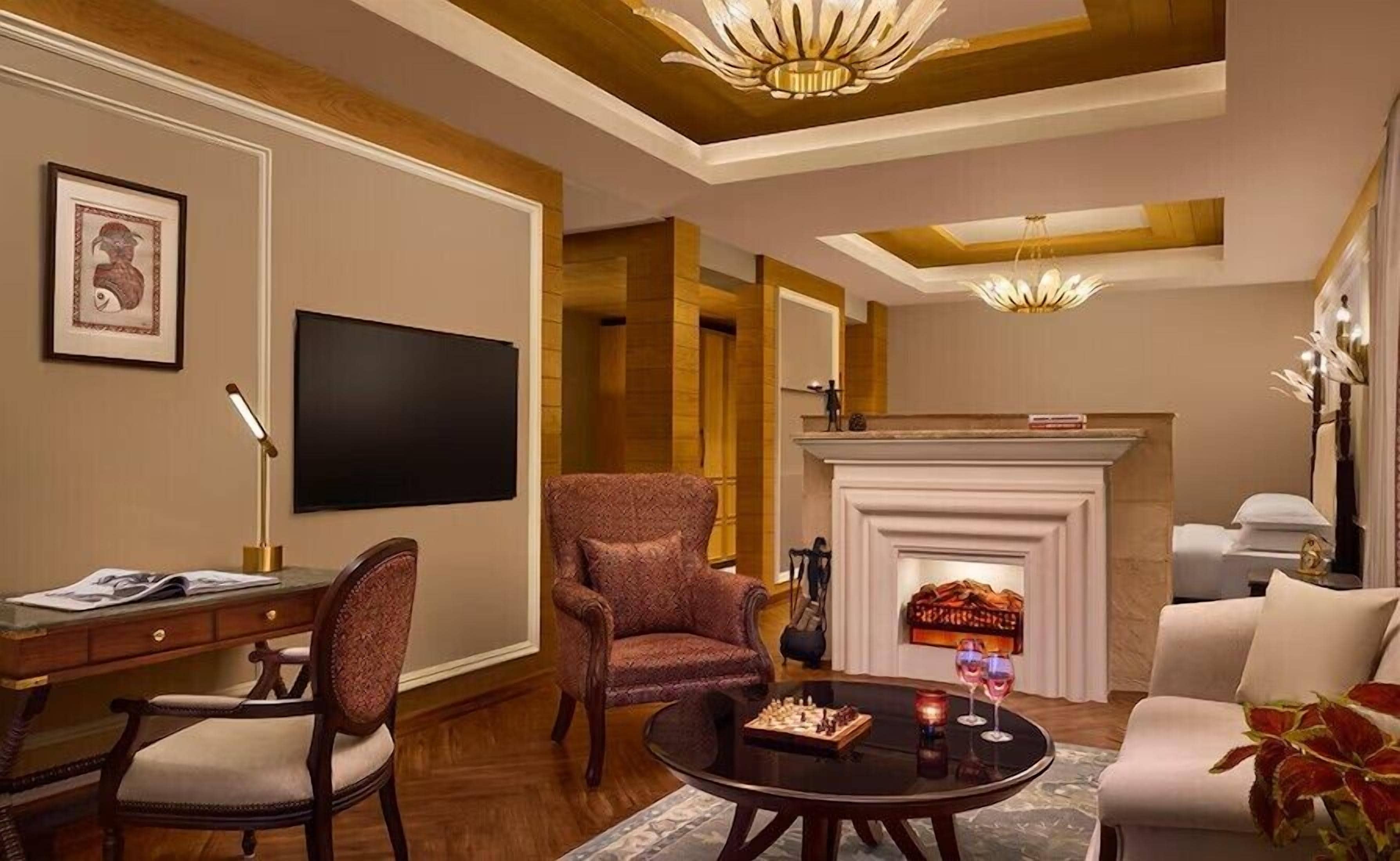 A living room with a fireplace, a television, and a dining area with chairs and a table.
