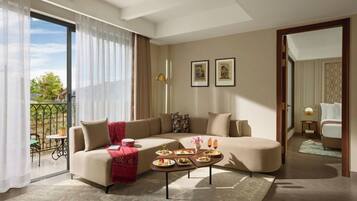 A modern living room with a sectional sofa, a coffee table with food, and a balcony with a view.
