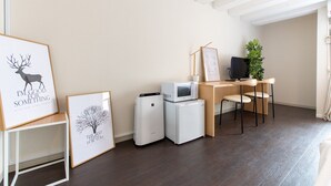 A modern office space with a wooden desk, two chairs, a computer, a microwave, and a refrigerator. There are framed pictures on the wall and a plant on the desk. - 2min walk from Nakano Station 1min walk to Nakano Broadway MAX6 Guests(4) (中野区中野)
