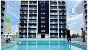 Un bâtiment moderne doté de nombreux balcons et d’une piscine située à l’avant.
