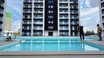 Un edificio moderno con varios balcones y una piscina delantera.