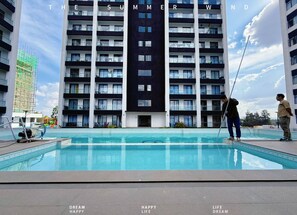 A modern building with multiple balconies and a swimming pool in front. - JKIA luxury units (Syokimau)