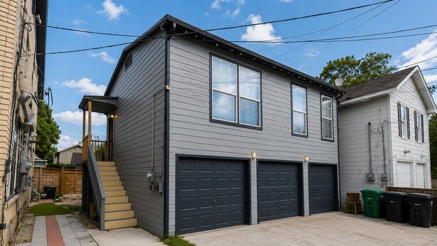 A two-story house with a garage, a staircase, and a small front yard.