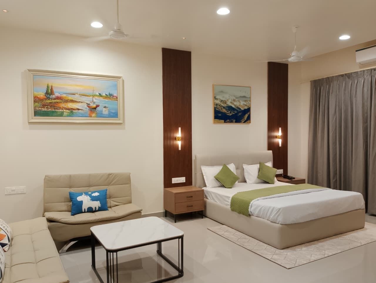 A modern bedroom with a bed, bedside tables, a sofa, and a coffee table.