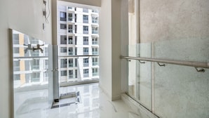 A modern interior with a glass door leading to a balcony, a marble floor, and a view of a high-rise building. - Yaya Suites (Nairobi)
