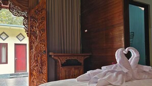 Una habitación de hotel con una cama, un armario de madera y vistas al exterior.