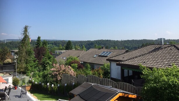 Un quartier résidentiel avec des maisons, une clôture en bois et un ciel dégagé.