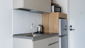 Cozinha moderna com fogão embutido, chaleira e micro-ondas na bancada.