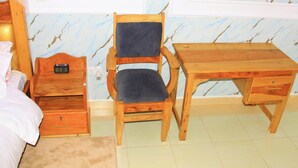 A bedroom with a bed, a wooden desk, a chair, a bedside table, and a nightstand. - Flo Homes White House Apartments, Thome Nairobi (Nairobi)