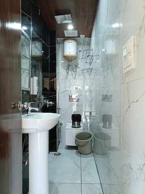 A bathroom with a white sink, a mirror, a towel rack, a toilet, and a shower area. - The Chail Pine Orchard Resort (Chail)