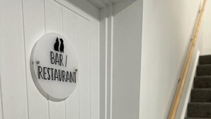 A white door with a sign that reads "BAR / RESTAURANT" and a wooden handrail next to a staircase. - Fox and Hounds Inn (Carmarthen)