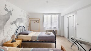A bedroom with a bed, bedside table, lamp, and a wall mural. - Gîte Du Centre with Private Terrace and Wi-Fi (Romorantin-Lanthenay)