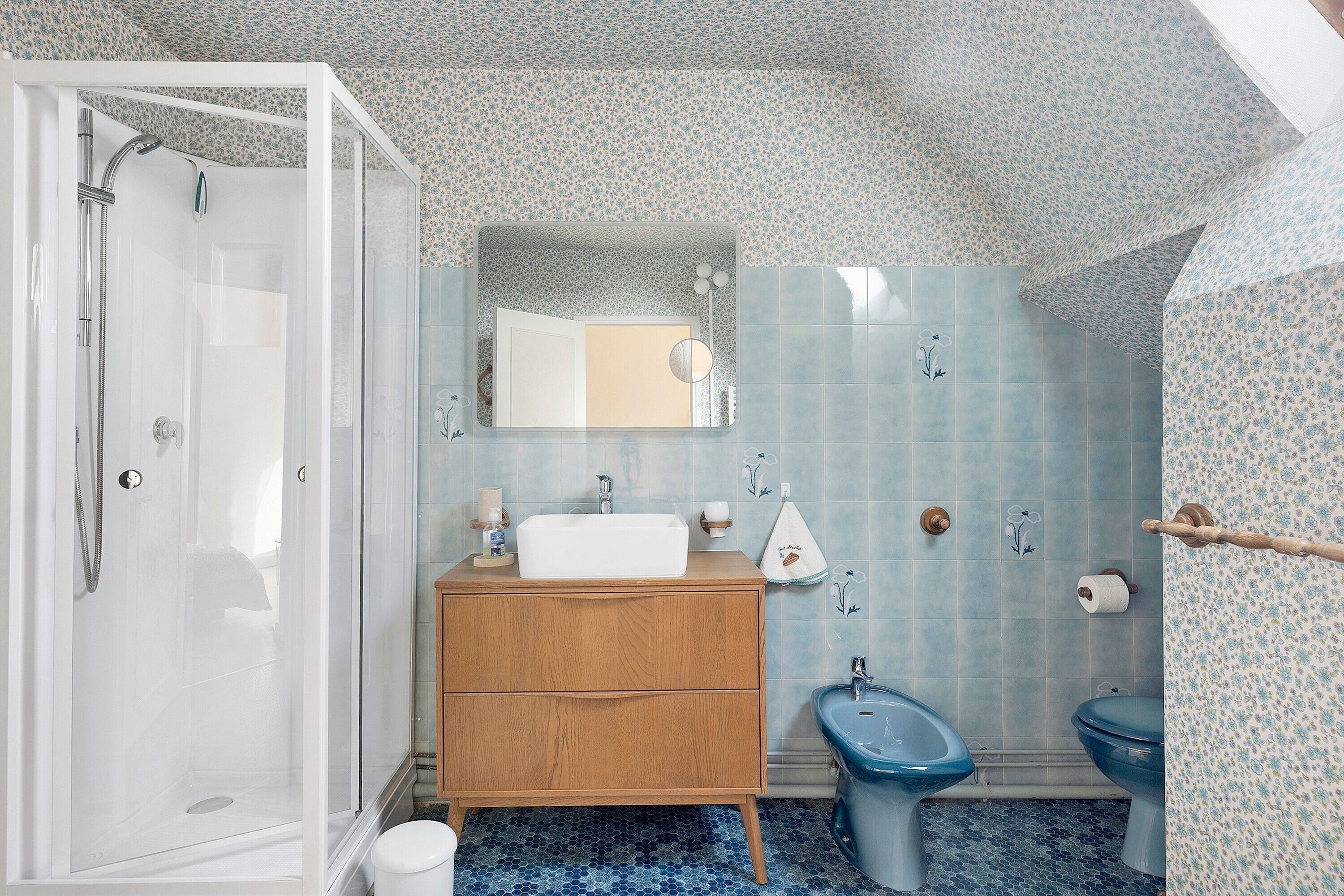 Une salle de bain équipée d’une douche, d’un lavabo, d’un bidet et d’un miroir.