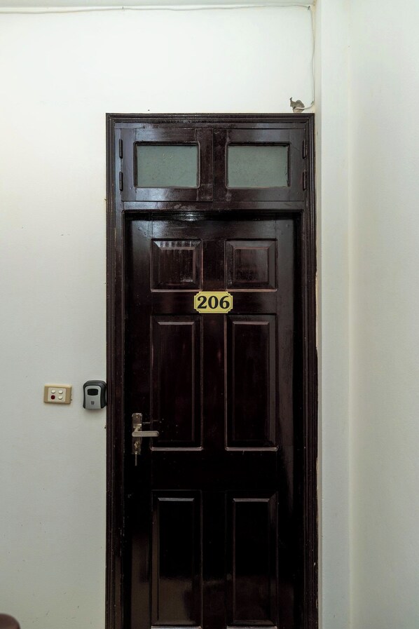 A dark wooden door with a number plate '206' and a small window above it.