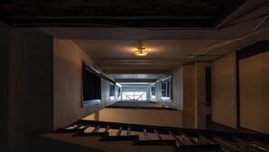 A dimly lit hallway with a staircase leading to an upper floor. - Homestay PW Hoang Sam (Hanoi)
