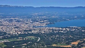 Luchtbeeld van een kuststad met een mix van stedelijk en landelijk gebied, inclusief een rivier, velden en een groot wateroppervlak.