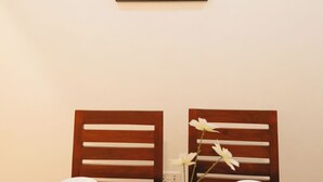 A dining table set with plates, cutlery, and a vase with flowers. - Freedomhomesairbnb (Arusha)