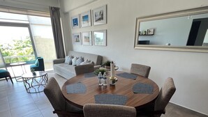 A modern dining area with a round table, six chairs, and a ceiling fan. - Feel at home in paradise/ A few minutes from the beach. (Nuevo Vallarta)