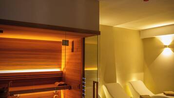 A modern spa room with a wooden sauna, glass-enclosed relaxation area, and ambient lighting.
