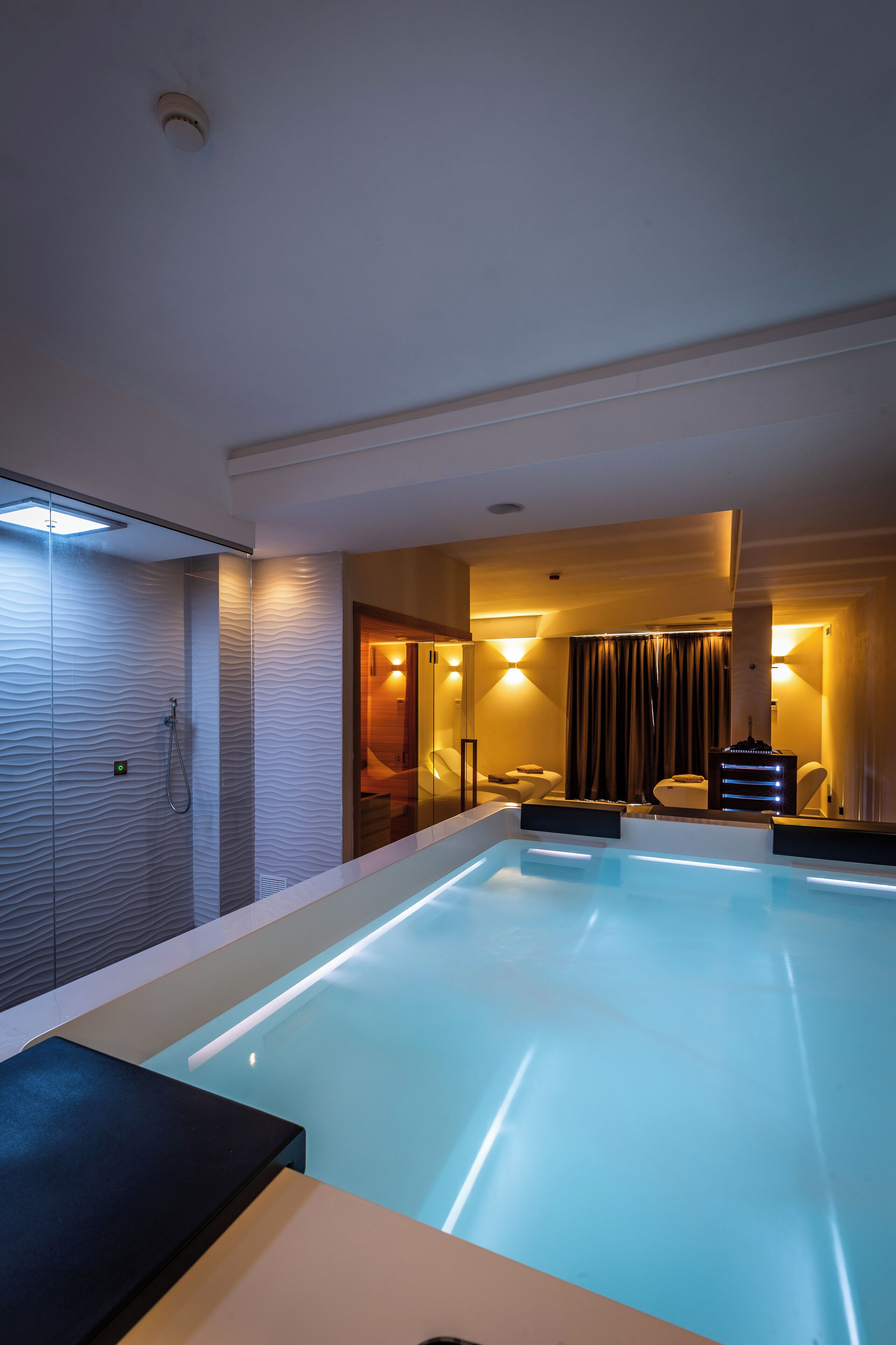 A modern bathroom with a glass-enclosed shower, a large bathtub, and a separate shower area.