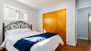 Une chambre à coucher avec un lit, une porte en bois et une fenêtre.