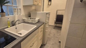 A compact kitchen with a sink, countertop, and storage cabinets.