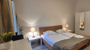 A hotel room with a bed, bedside tables, a wardrobe, a chair, and a desk. - Charming 1BR Apt Near Central Vienna (Vienna)