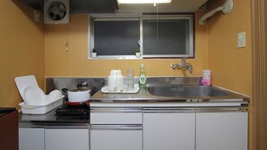 A compact kitchen with a sink, stove, and cabinets.