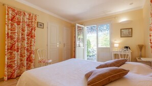 Ein Schlafzimmer mit Bett, Stuhl, Schreibtisch und Fenster.