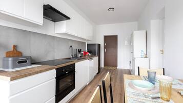 Appartement (4) | Privékeuken | Een koelkast met diepvriezer, een microgolfoven, een kookplaat