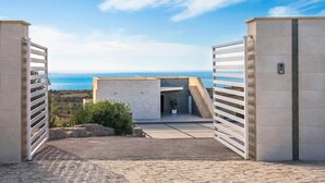 A modern building with a stone pathway leading to a gated entrance. - Villa Lily with private pool - My Rental Homes (Montallegro)