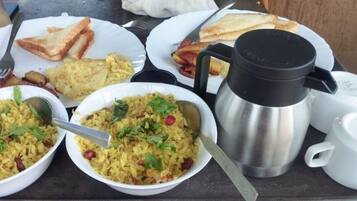 Un desayuno con platos de comida, una cafetera y utensilios.