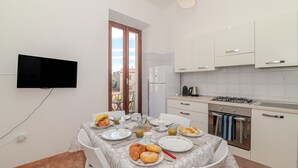 Eine moderne Küche mit weißen Schränken, einem Gasherd und einem Essbereich mit Frühstückstisch.