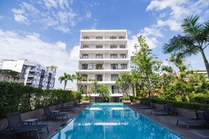 A modern building with a pool and lounge chairs. - Cozy Apartment-1BR T2-524 (Chalong)