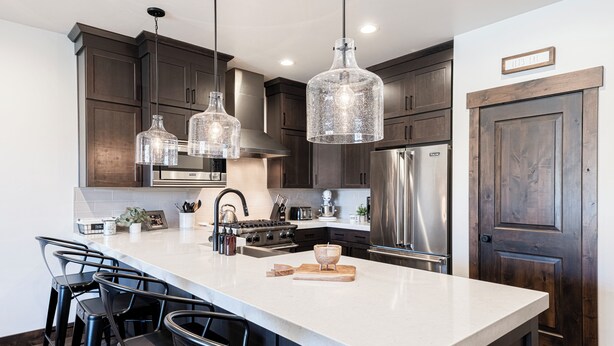 A modern kitchen with dark wood cabinets, stainless steel appliances, and a large island with bar stools. - Family-Friendly Escape w/ Hot Tub & Views | Near Jordanelle & Ski Resorts (Hideout)