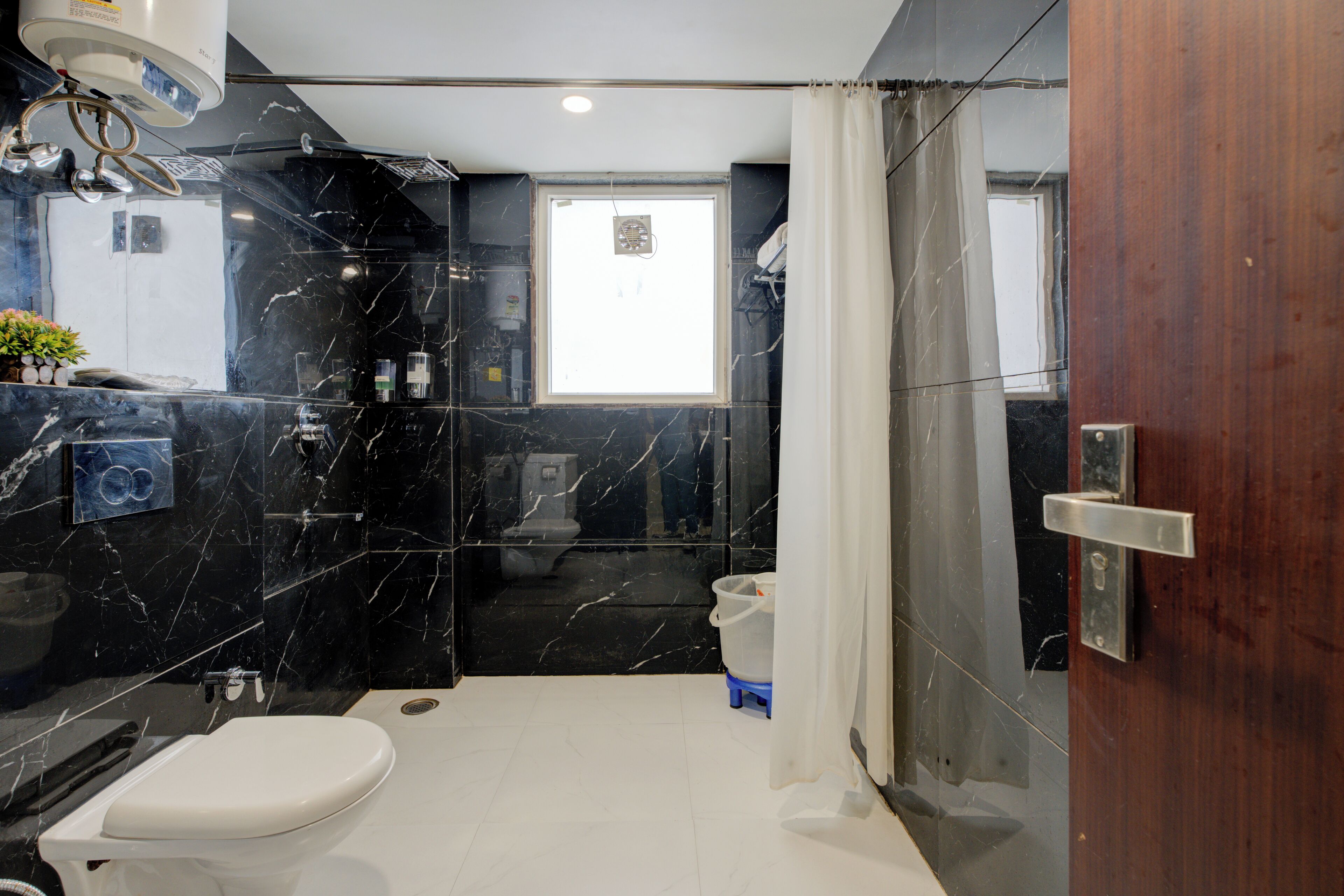 Une salle de bain moderne équipée de toilettes, d’un lavabo et d’une zone douche.