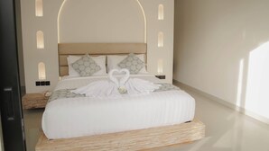 Une chambre moderne avec un grand lit, une tête de lit en bois et des luminaires fixés au mur.