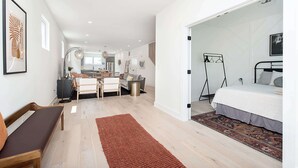 A modern bedroom with a bed, bedside table, and a large window. - Modern Luxe Retreat | Hot Tub | Garage | Near DT (Indianapolis)