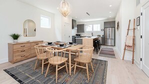 A modern kitchen with wooden cabinets, a central island, and a stainless steel refrigerator. - Modern Luxe Retreat | Hot Tub | Garage | Near DT (Indianapolis)