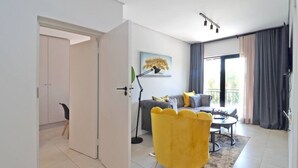 A modern living room with a sofa, a yellow armchair, and a floor lamp.