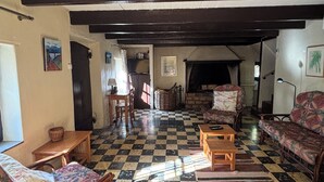 A room with a checkered floor, wooden furniture, and a fireplace.