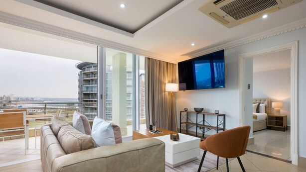 A modern living room with a sofa, coffee table, and TV.