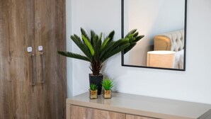 A wooden wardrobe with two small potted plants on top.