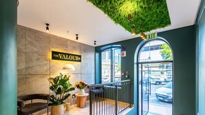 A hotel lobby with a reception desk, a sign reading "The Valour," a plant, and a wet floor sign. - 602 The Valour Luxurious Apartment (Cape Town)