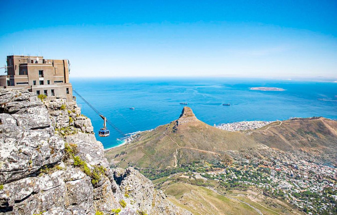 A cable car system, a mountainous landscape, and a coastal town.