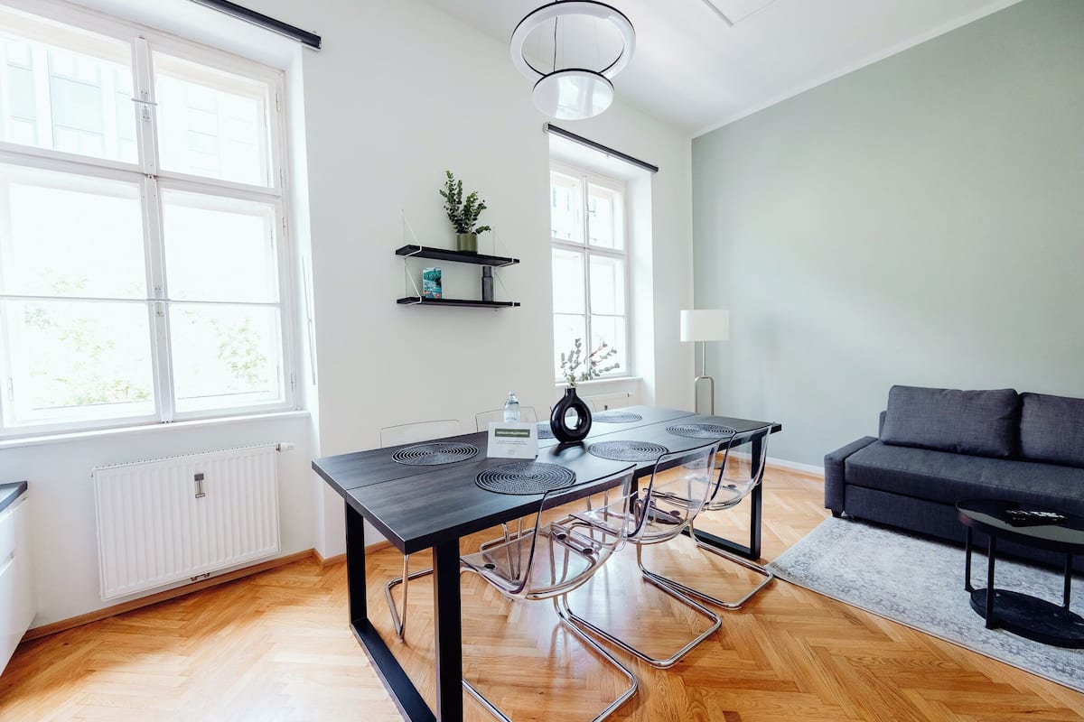 Un salon moderne comprenant une table à manger, des chaises, un canapé et une table basse.