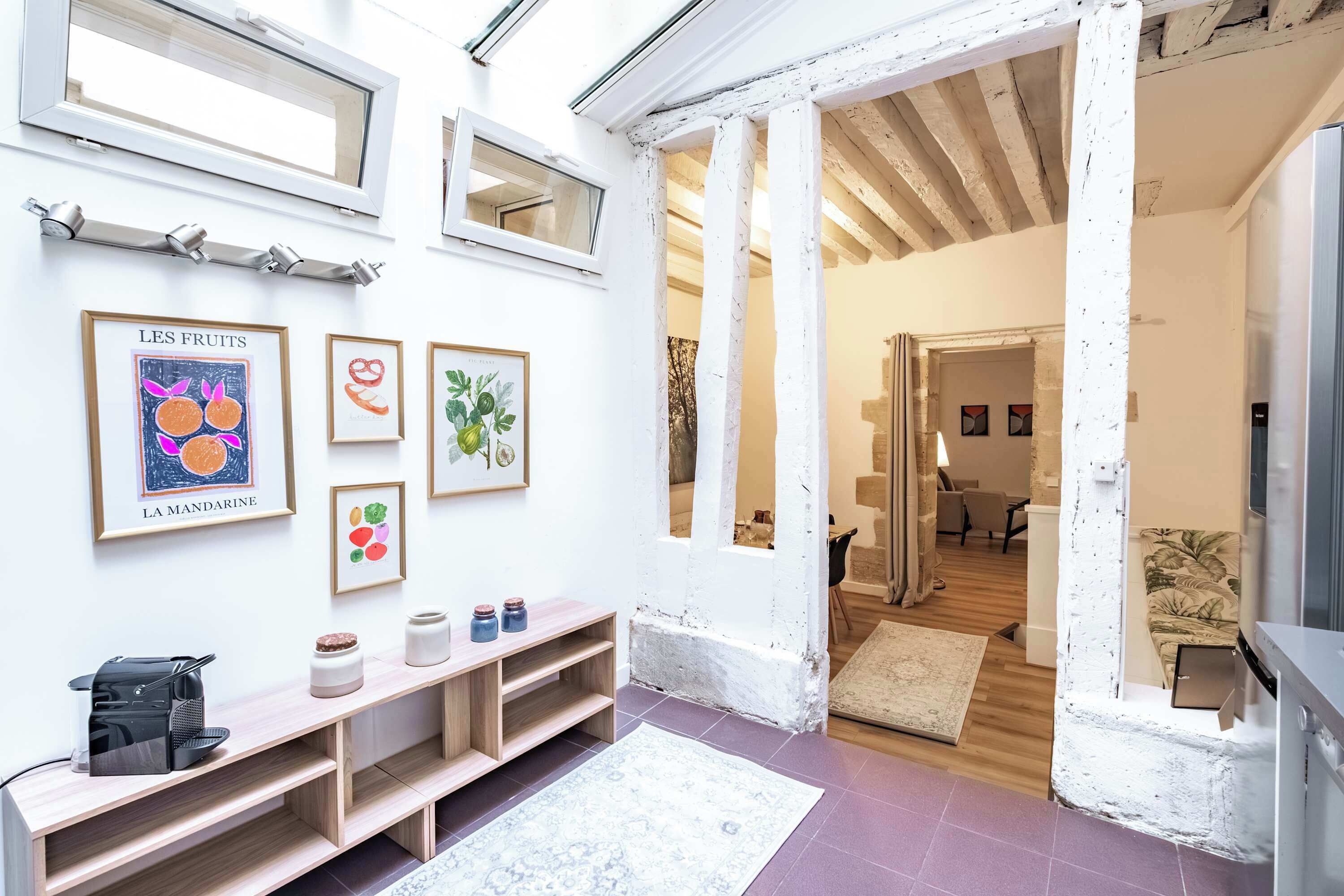 A modern interior with a wooden bench, framed artwork, and a white door leading to another room.