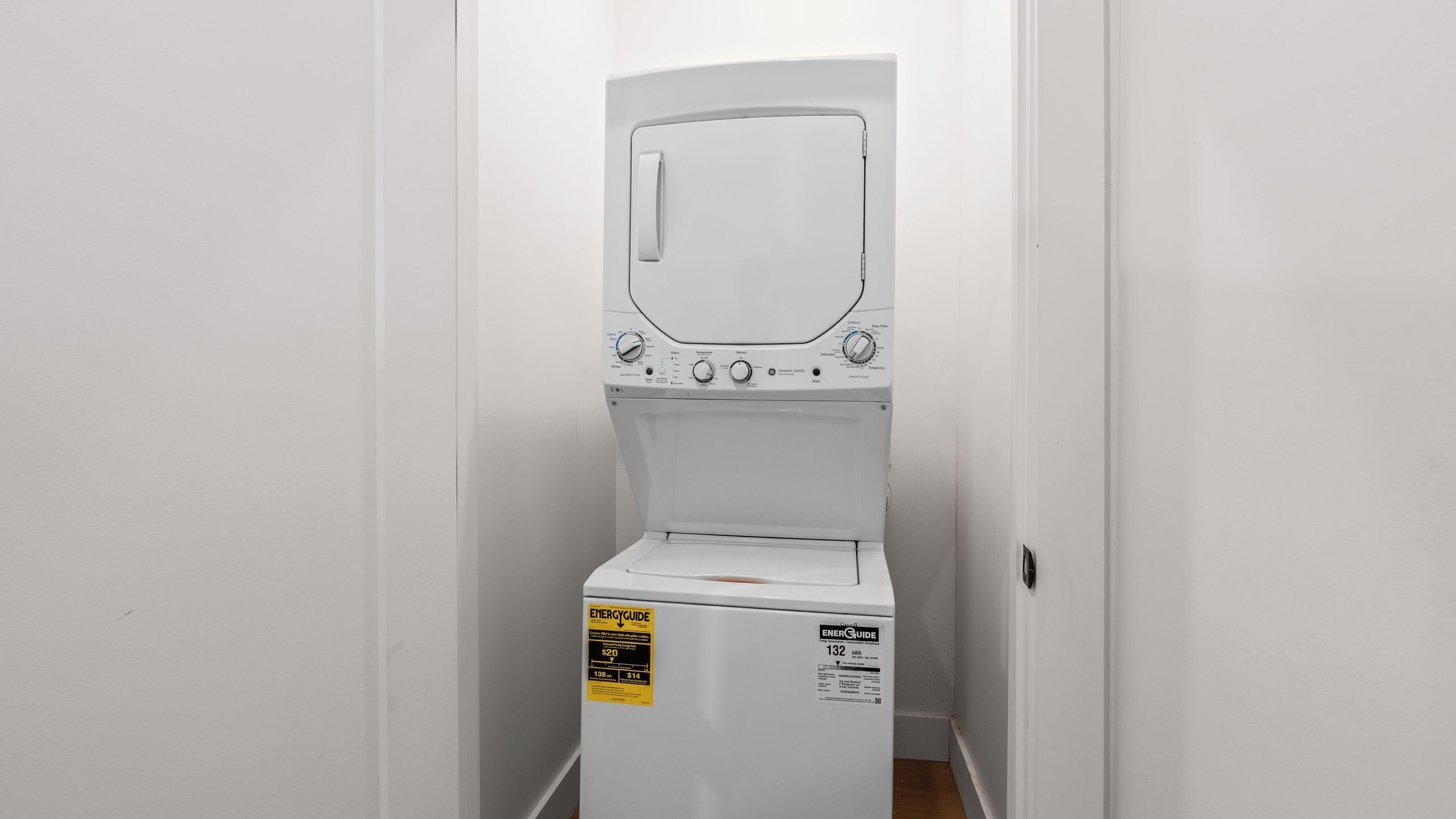 Un appareil compact, blanc, combinant une machine à laver et un sèche-linge à chargement frontal, doté d’un panneau de commande, d’une étiquette d’information sur la consommation d’énergie et d’un autocollant attestant de sa certification ENERGY STAR.