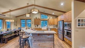 A spacious kitchen with wooden cabinets, a large island, and a dining area with bar stools.